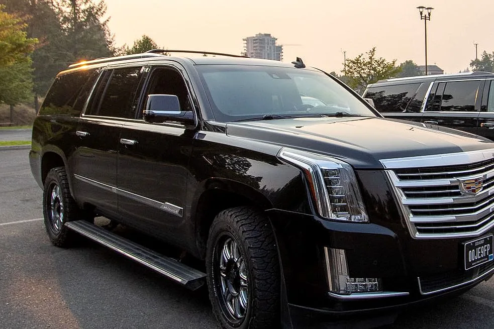 The RoadStars Cadillac Escalade ESV at sunset with the Spokane skyline behind it